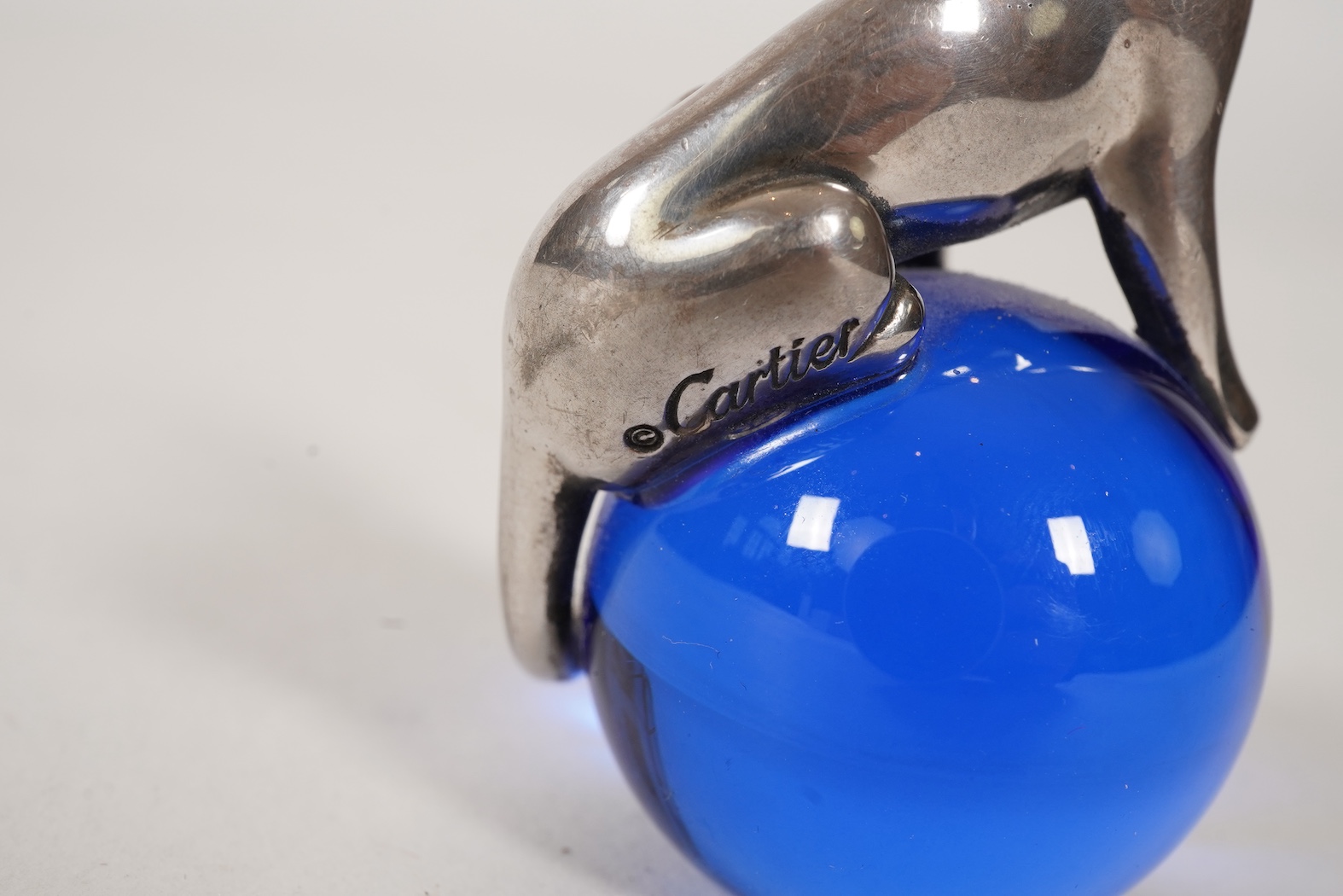 A recent Cartier paperweight, modelled as a panther upon a blue glass sphere